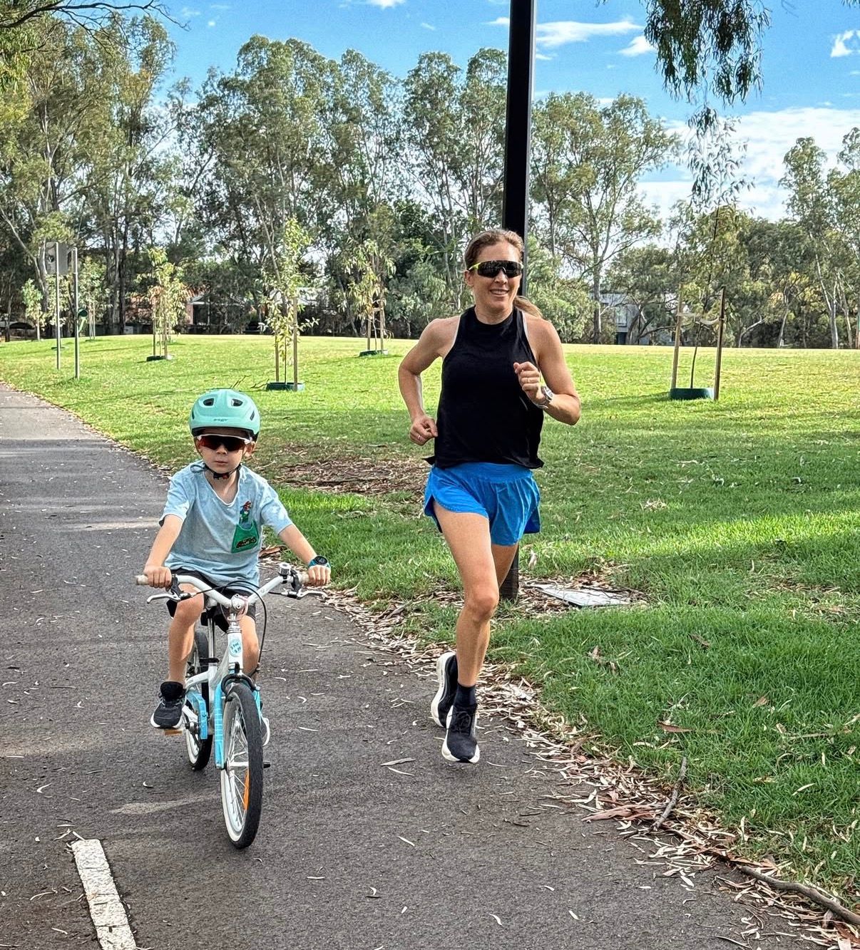 Jessica Stenson running beside a child on a bike