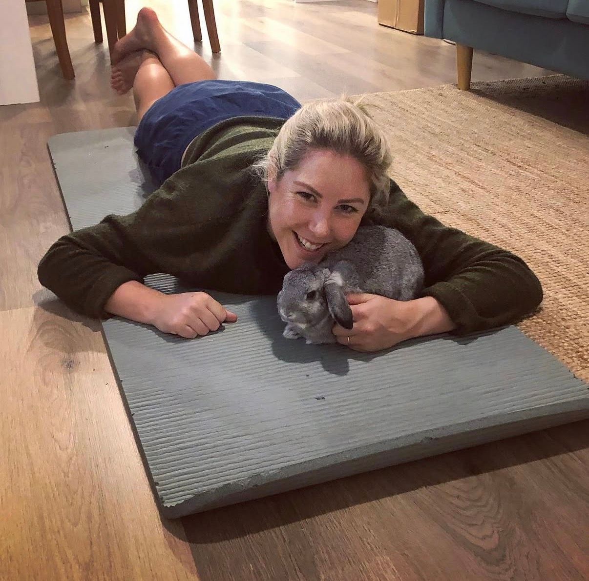 Alicia Hayes on a Pilates mat with a rabbit